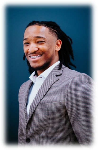 A man with dreads in a suit and tie.